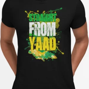 A black crewneck T-shirt with a vibrant graphic print that reads 'STRAIGHT FROM YAAD' in a large, distressed typeface with splatters of green, yellow, and black paint around the words, reflecting the Jamaican flag colors. This T-shirt is featured on the Jamaican clothing online store, DiGoodTingsDem.com