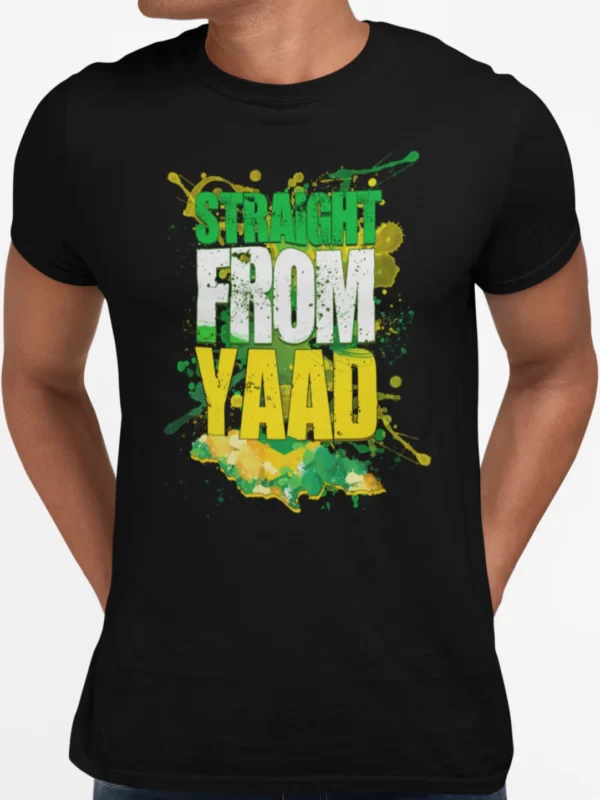 A black crewneck T-shirt with a vibrant graphic print that reads 'STRAIGHT FROM YAAD' in a large, distressed typeface with splatters of green, yellow, and black paint around the words, reflecting the Jamaican flag colors. This T-shirt is featured on the Jamaican clothing online store, DiGoodTingsDem.com